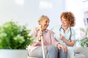 A group of older adults smiling and talking together in a bright, comfortable common area.