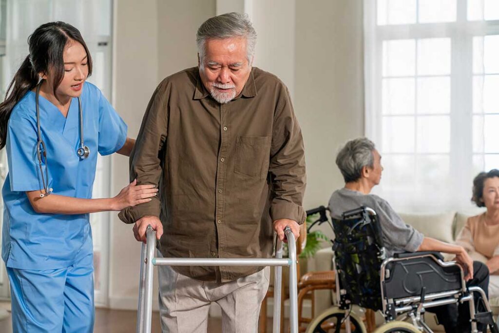 Senior using a handrail in a well-lit assisted living hallway with clear pathways and high-contrast signs
