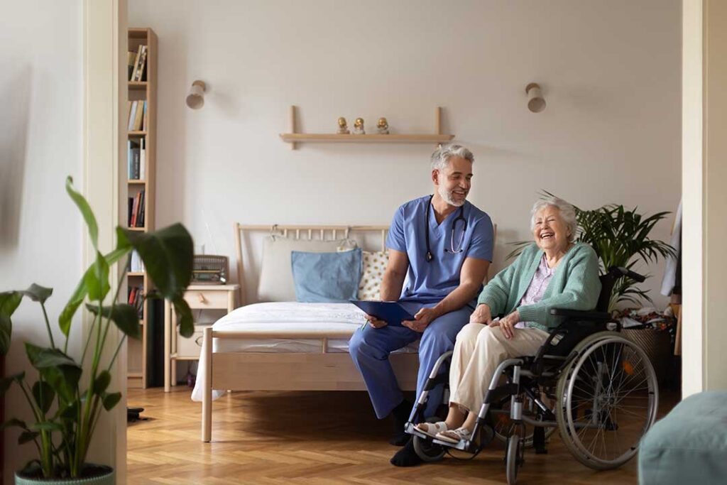 Older LGBTQ+ adults and caregivers having a respectful conversation in a bright assisted living common room.